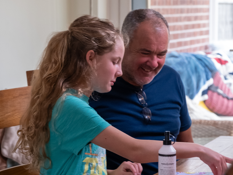 Young girl and foster parent sitting at a table